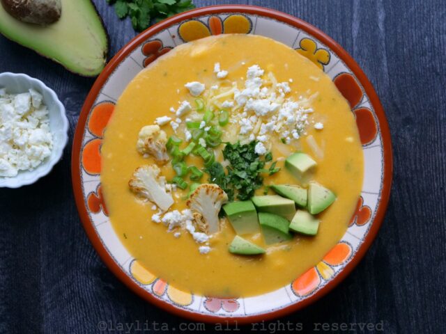 Sirva a sopa decorada com coentro picado adicional, cebolinho picado, abacate, queijo extra, pedaços de couve-flor fritos