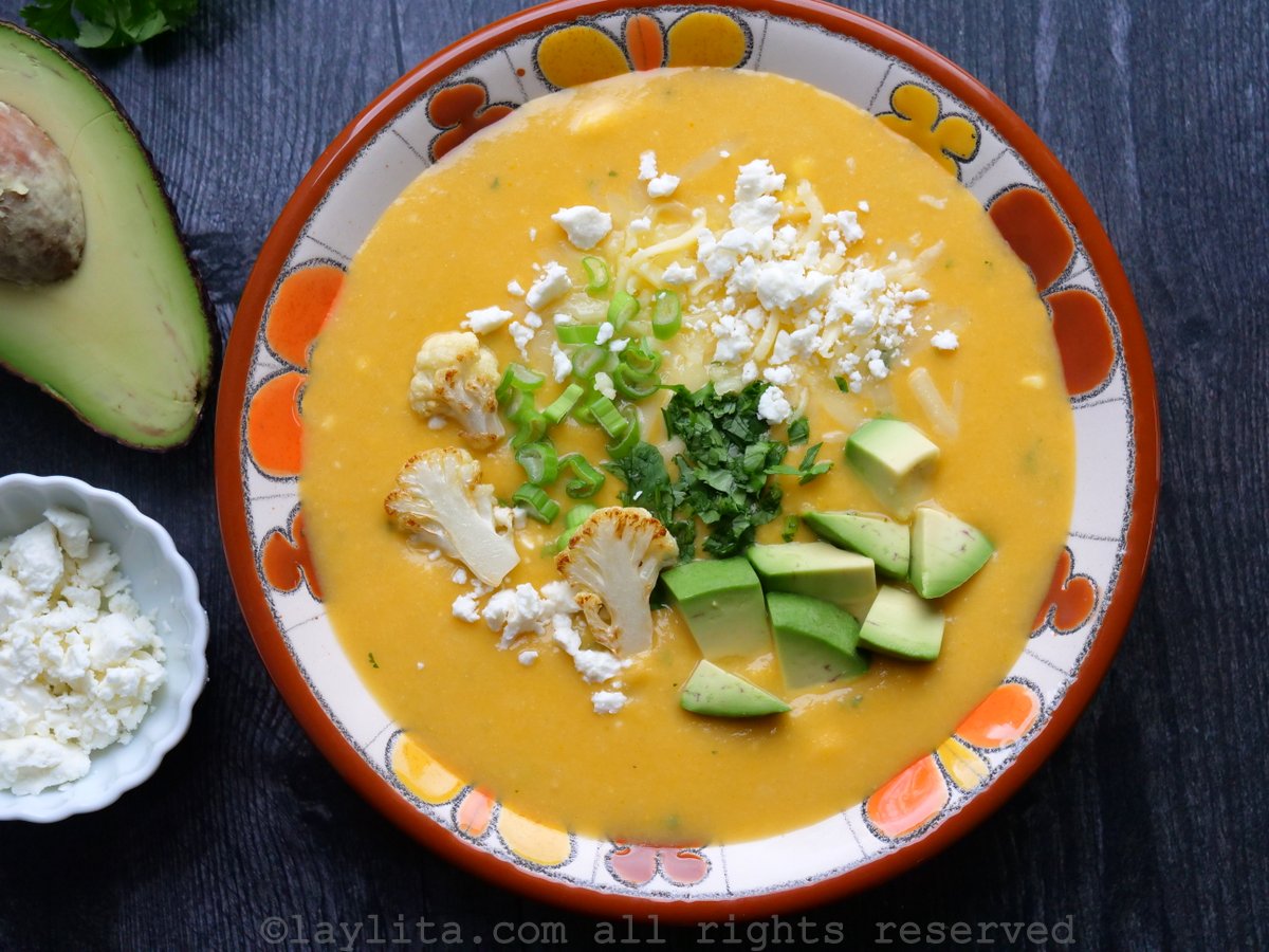 Locro equatoriano de couve-flor em uma tigela florida com abacate e queijo.
