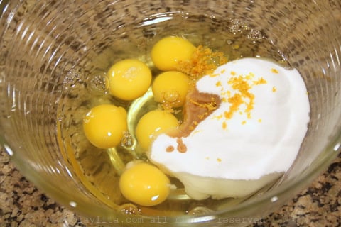 Ponga los huevos, azucar, esencia de vainilla, y ralladura de limon en un tazon grande