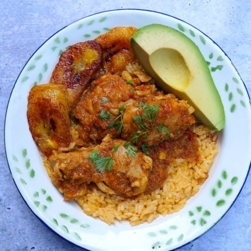 Seco de pollo con arroz amarillo, aguacate y plátanos fritos