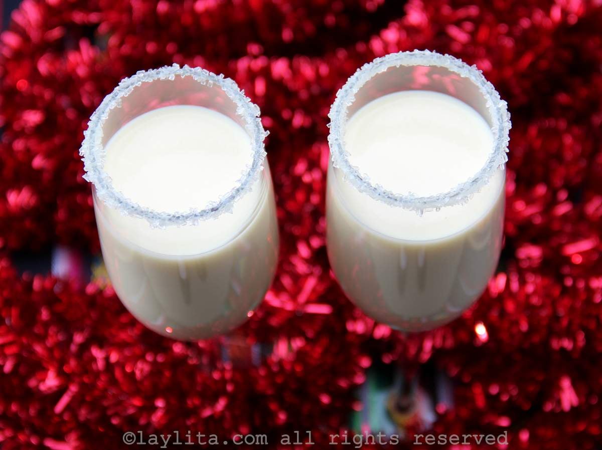 Dos copas de rompope con cintas rojas navideñas alrededor