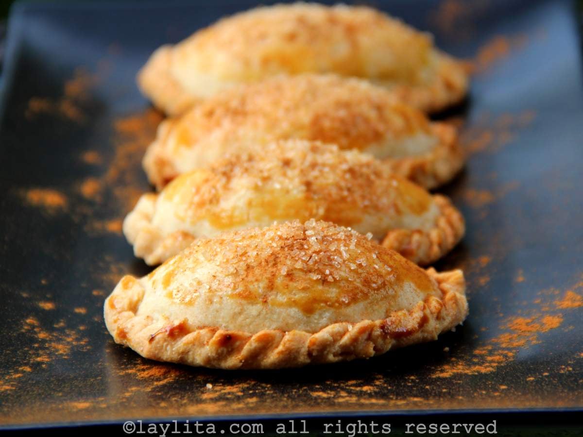 Cuatro empanadas dulces de calabaza en un plato negro