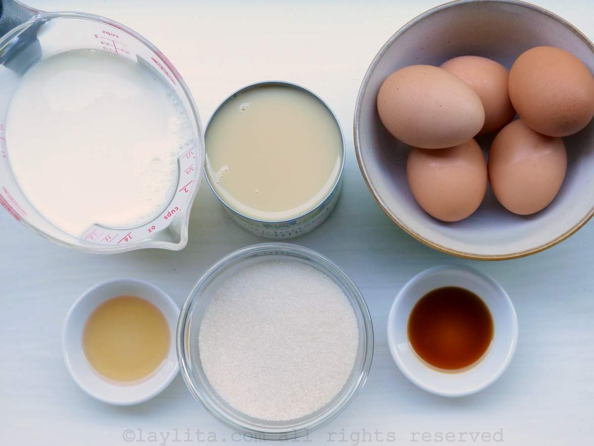 Ingredientes del Quesillo Venezolano en una mesa blanca: Huevos, azucar, leche, vainilla, ron, leche condensada