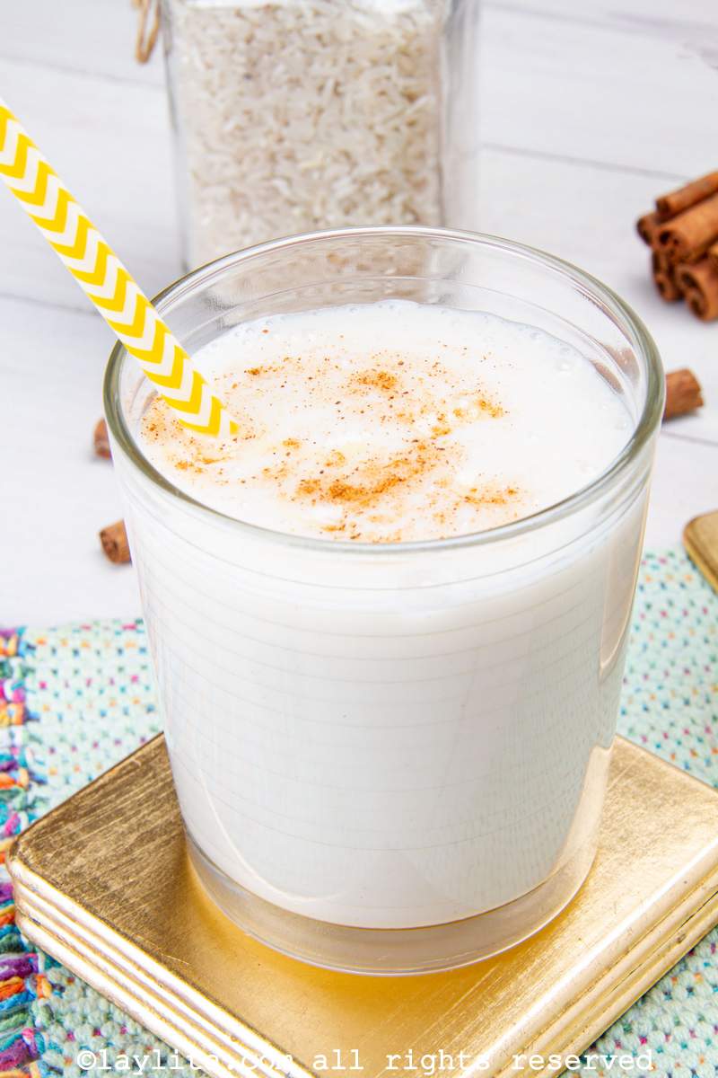 Un vaso de chicha criolla venezolana bien helada con un sorbete amarillo