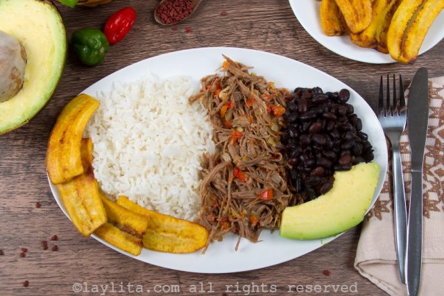 Pabellón venezolano con caraotas negras, carne mechada, arroz, tajadas y aguacate