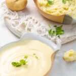Dos recipientes llenos de pu´re de papas, el primero es una variación francesa cremosa y la de atrás es un puré casero rustico