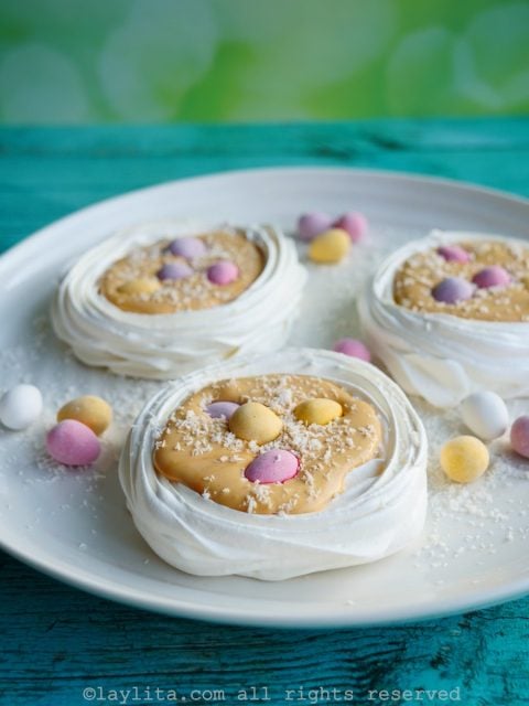 Rellena los nidos de merengue con la crema de dulce de leche y decora al gusto