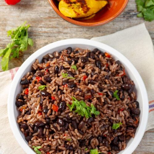 Un plato blanco lleno de gallo pinto costarricense o arroz con frijoles
