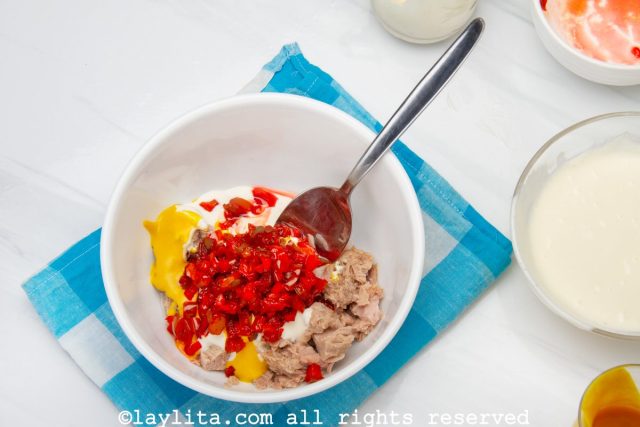 Mezclar el atún desmenuzado con la mayonesa restante, la salsa tártara, una cucharada de mostaza y los pimientos caramelizados.