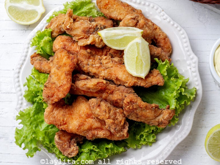Chicharrones de pollo en un plato con lechuga y rodajas de limón