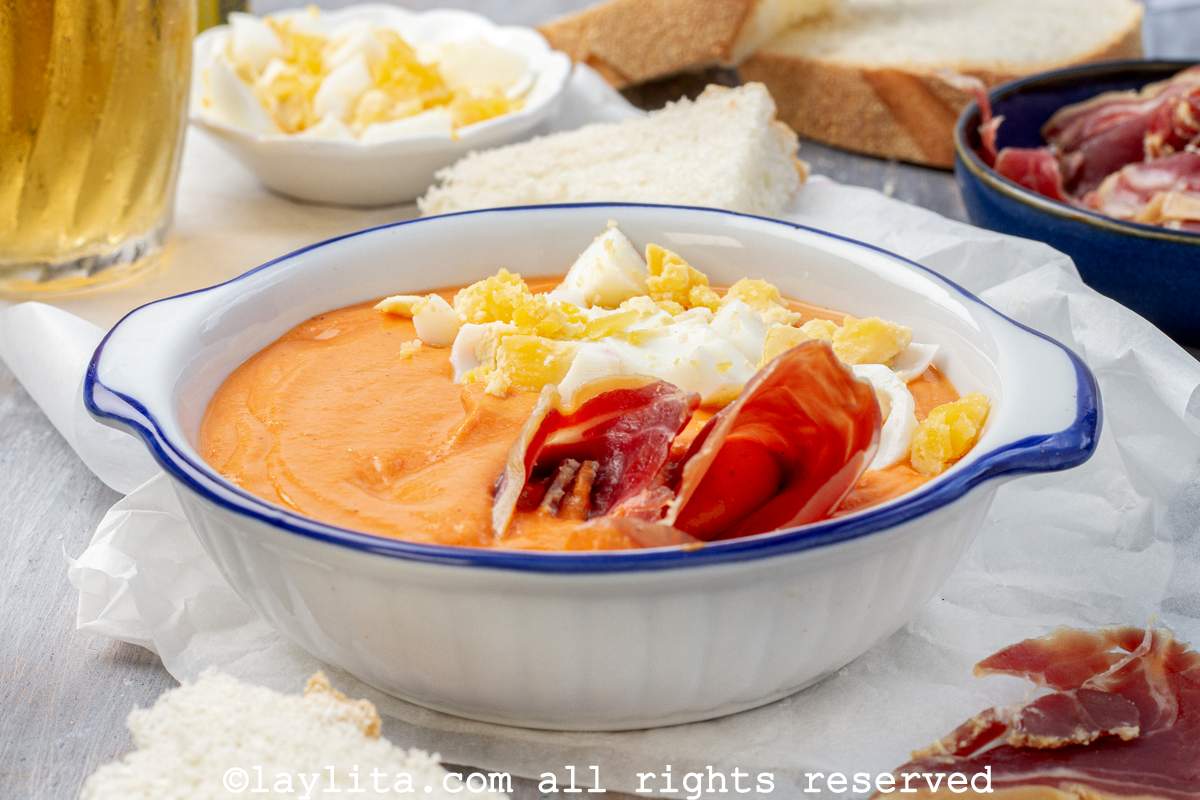 Salmorejo o crema fría de tomates en un plato hondo blanco con borde azul