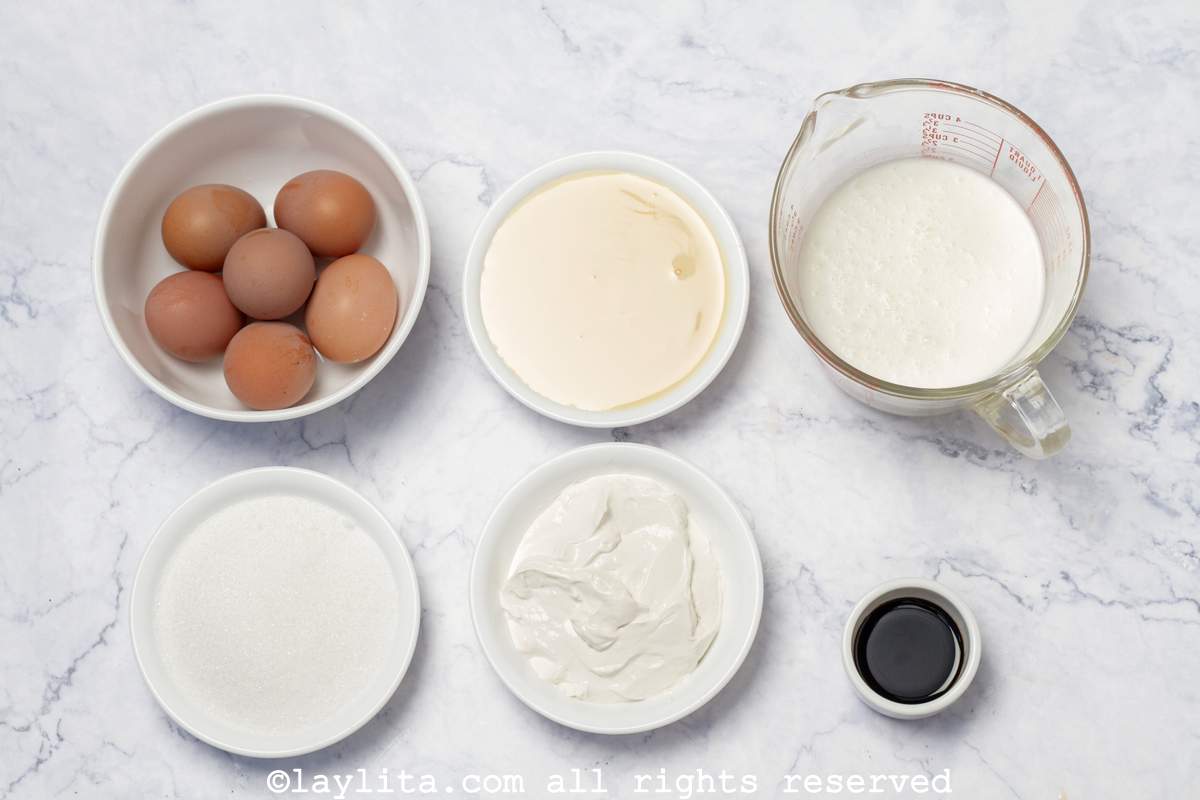 En una mesa se ven los ingredientes del Flan Napolitano: Huevos, queso crema, leche condensada, leche liquida o leche evaporada, esencia de vainilla, y azúcar para el caramelo