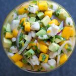 Ceviche de pecado con trozos de mango y aguacate servido en una copa de vidrio