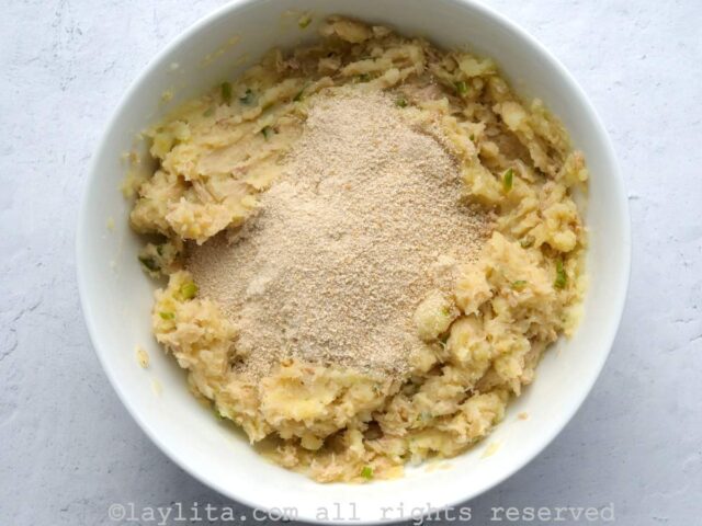 Mezclando el puré de papa y atún con las migas de pan