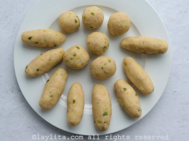 Un plato blanco con las croquetas de papa formadas en bolas y cilindros
