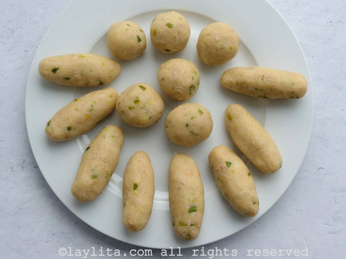 Un plato blanco con las croquetas de papa formadas en bolas y cilindros