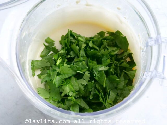 Preparando alioli verde o mayonesa de ajo y cilantro en la licuadora