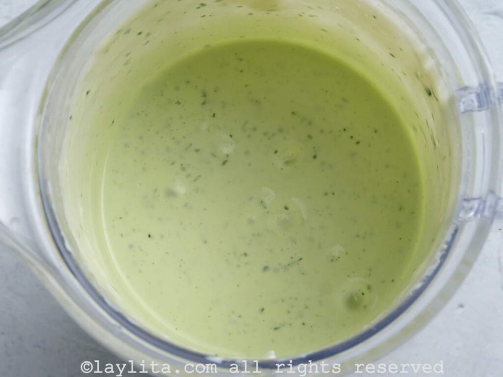 Preparando alioli verde o mayonesa de hierbas en la licuadora