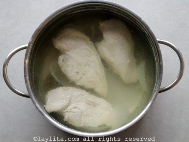 Una olla con 3 pechugas de pollo sancochadas