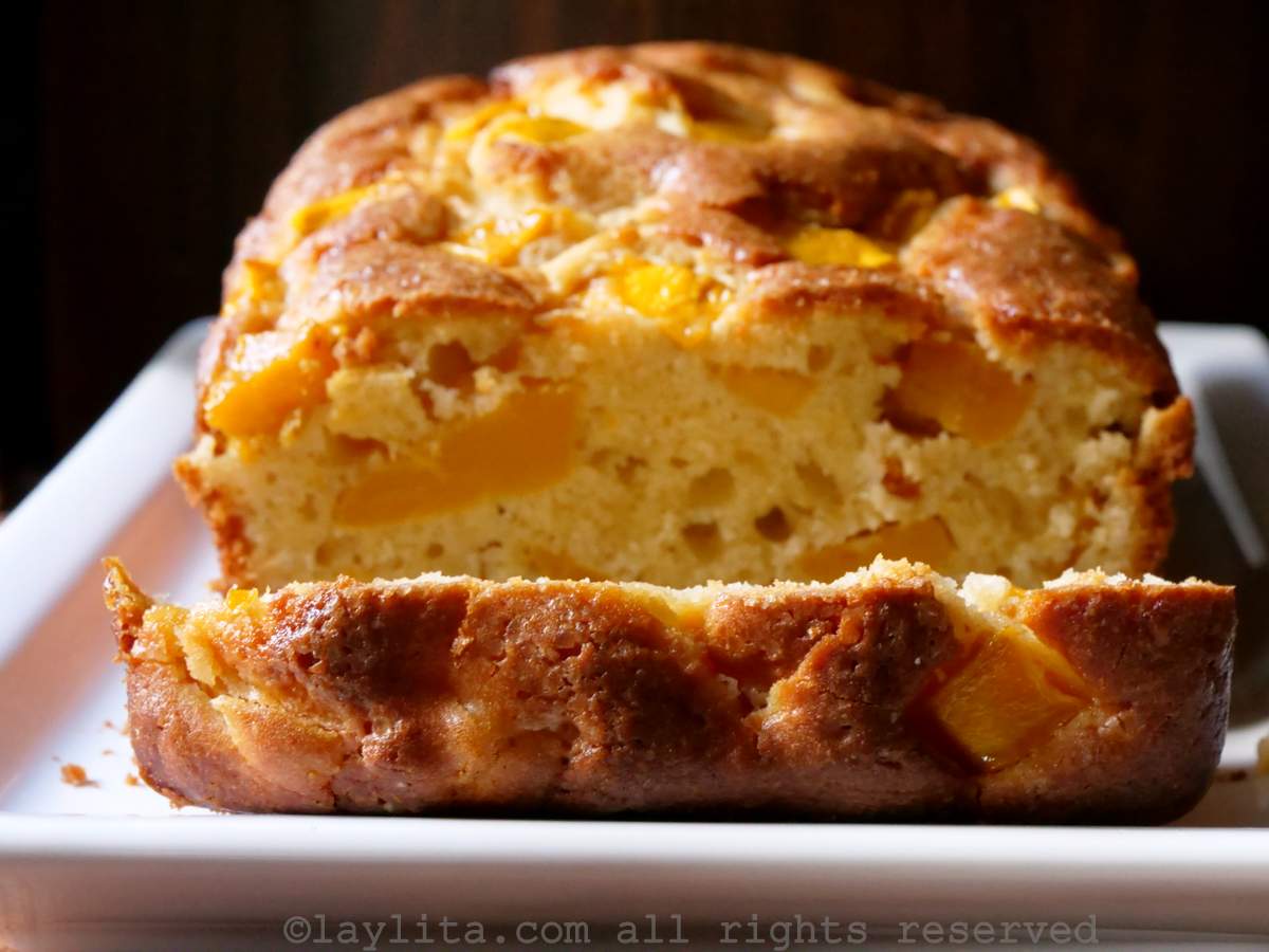 Un bizcocho o pan dulce de mango en un plato blanco con un trozo cortado
