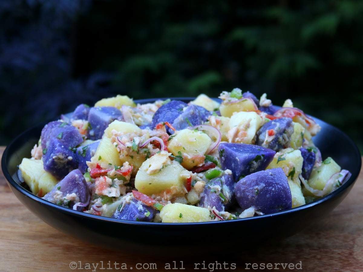 Un bol negro lleno de ensalada de papa morada con atún