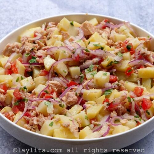 Un bol blanco lleno de ensalada de papas y atún