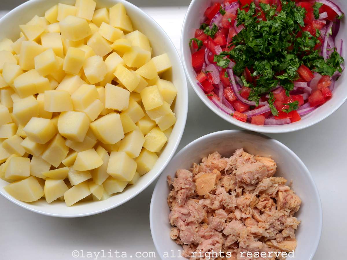 Ingredientes de la ensalada de papa y atún en una mesa blanca