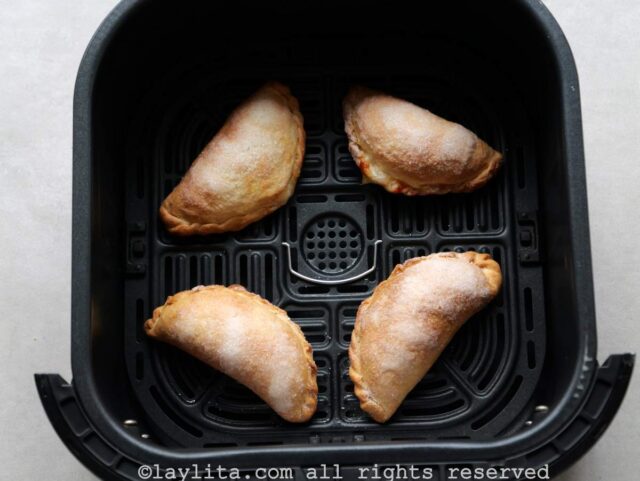 Cuatro empanadas ya cocidas en la freidora de aire