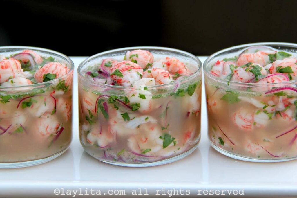 Ceviche de langostinos Tres vasos llenos de ceviche de langostinos rojos encima de una bandeja blanca