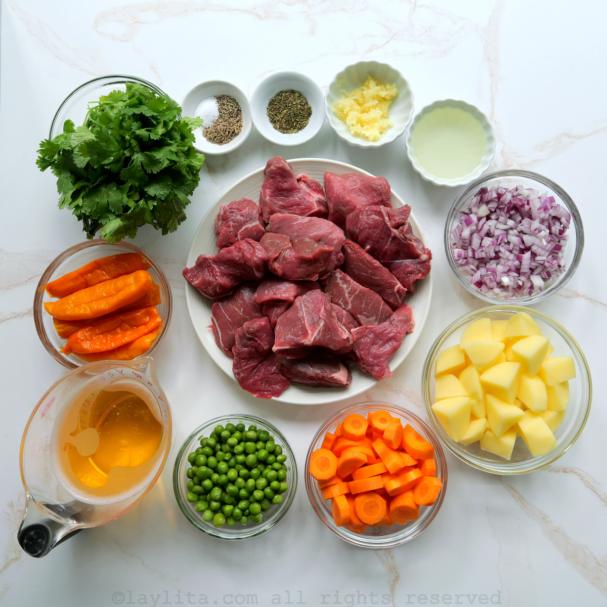 Ingredientes del seco de carne de res peruano en una superficie blanca