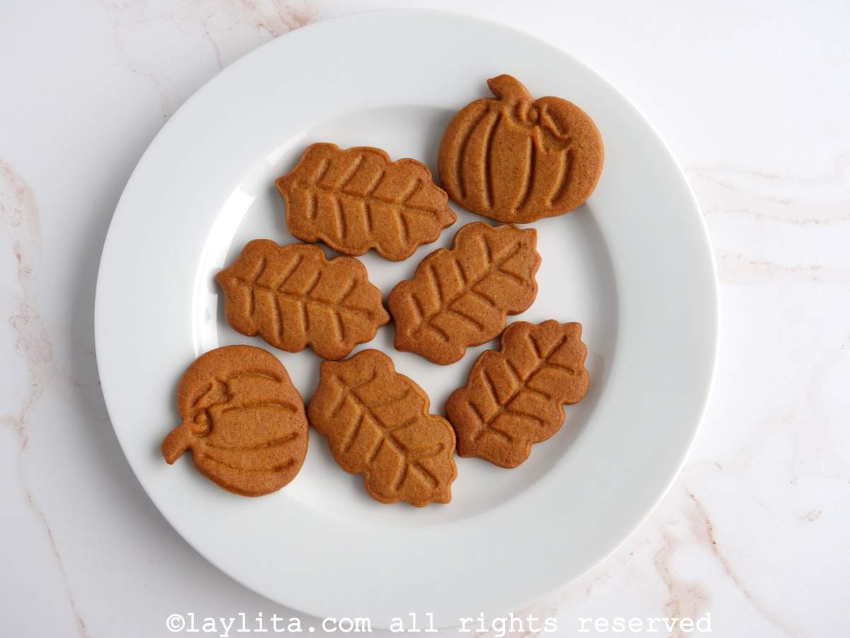Mini galletas de jengibre en forma de hojas otoñales y calabazas en un plato blanco