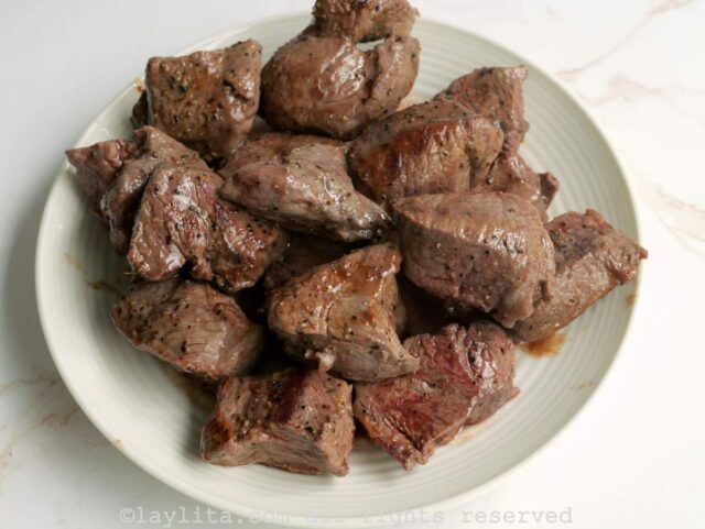 Pedazos de carne dorados en un plato blanco