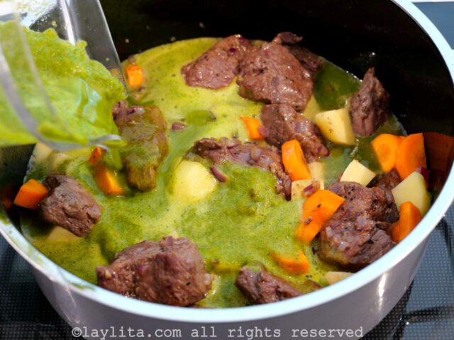 Agregando el liquido verde a la olla con la carne
