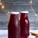 Dos botellas pequeñas llenas de sirope de arándano rojo