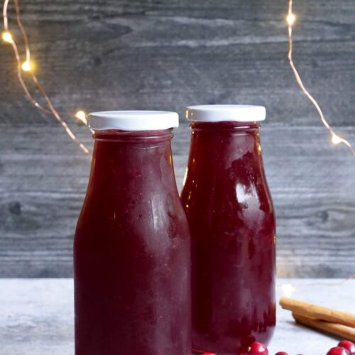 Dos botellas pequeñas llenas de sirope de arándano rojo