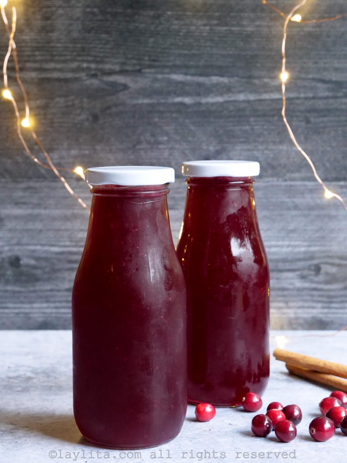 Dos botellas pequeñas llenas de sirope de arándano rojo