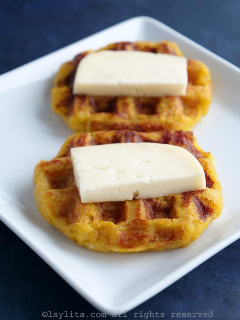 Dos waffles de plátano maduro con queso encima en un plato blanco