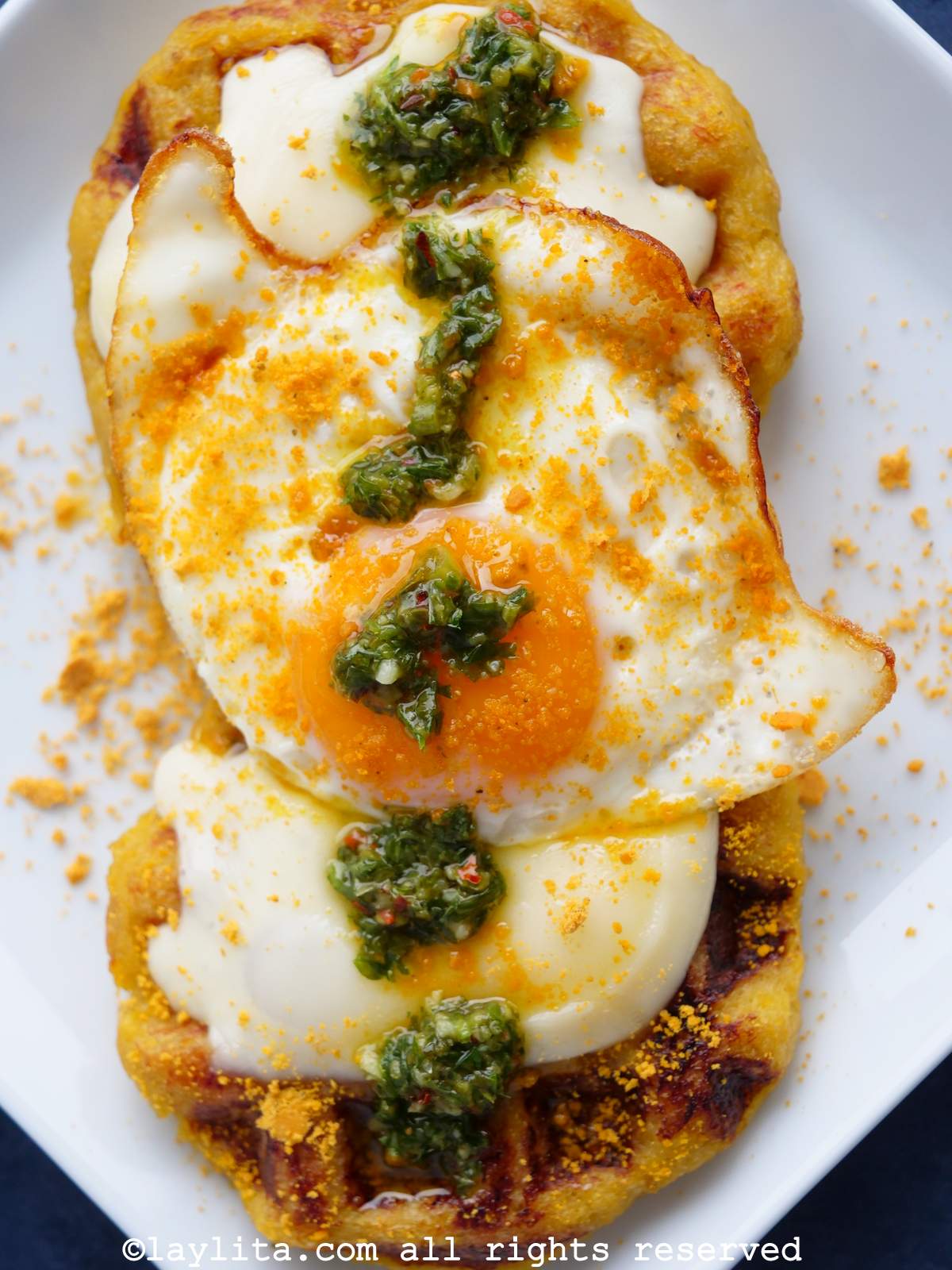 Dos gofres de plátano macho con queso, huevo frito y chimichurri
