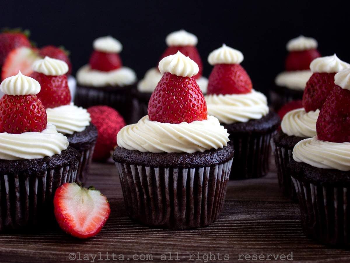 Una dozena de cupcakes de chocolate decorados con gorros de Papá Noel