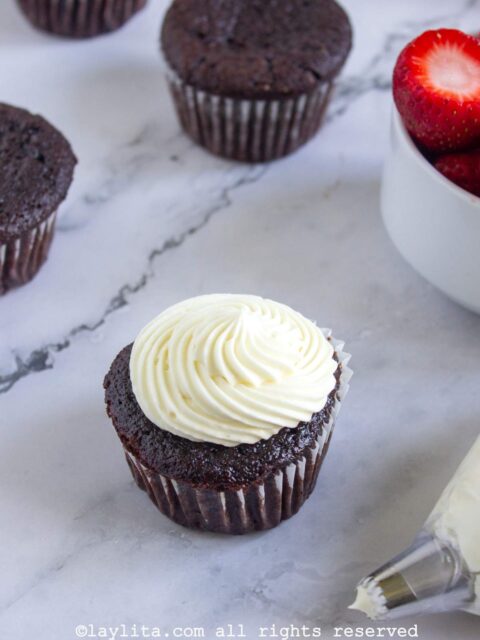 Un cupcake de chocolate decorado con cobertura blanca