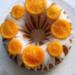 Un pastel de naranja al estilo Bundt decorado con naranjas confitadas