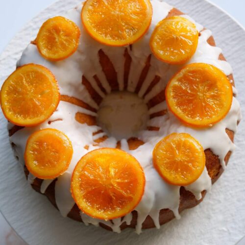 Un pastel de naranja al estilo Bundt decorado con naranjas confitadas
