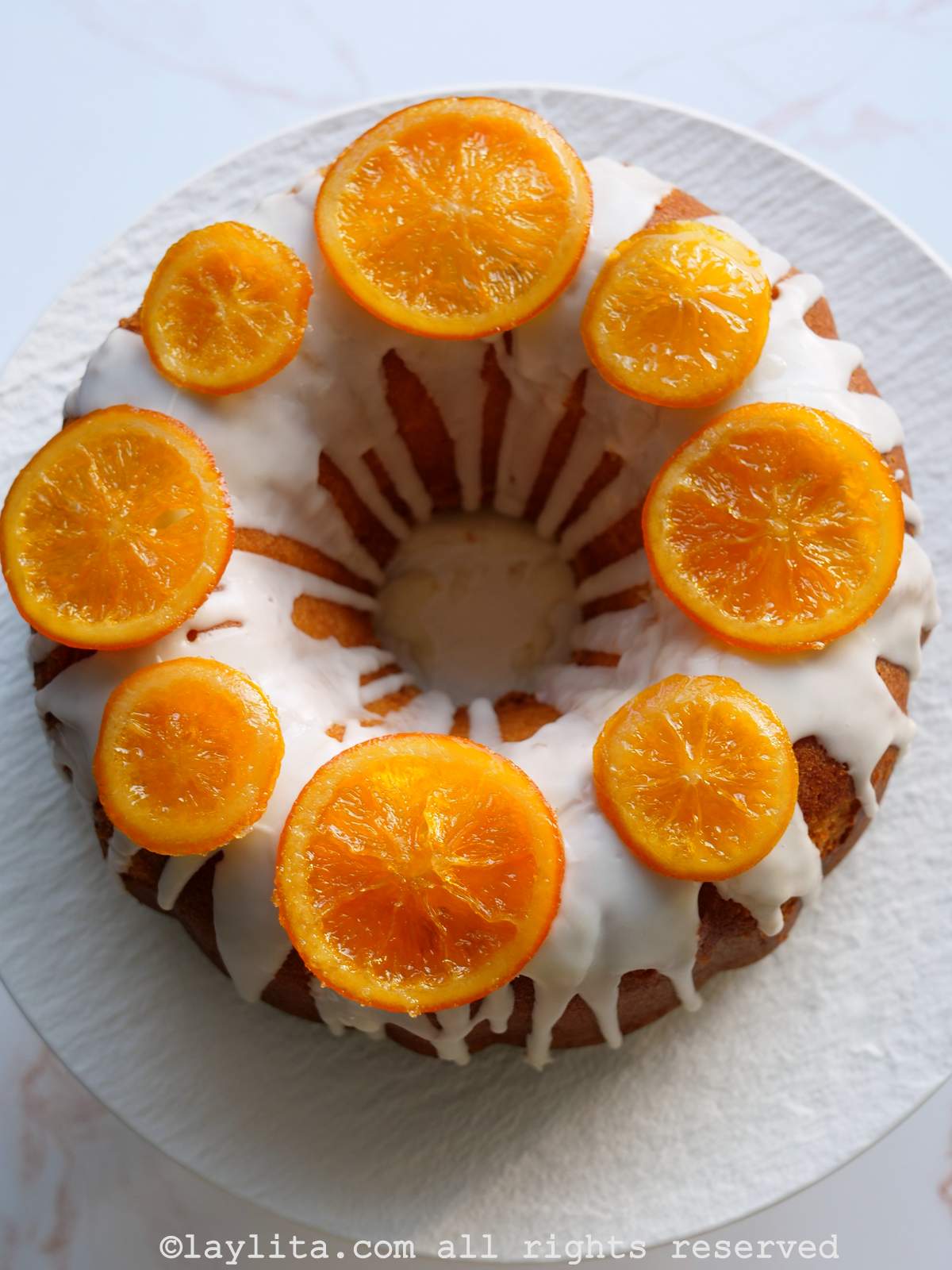 Un pastel de naranja al estilo Bundt decorado con naranjas confitadas
