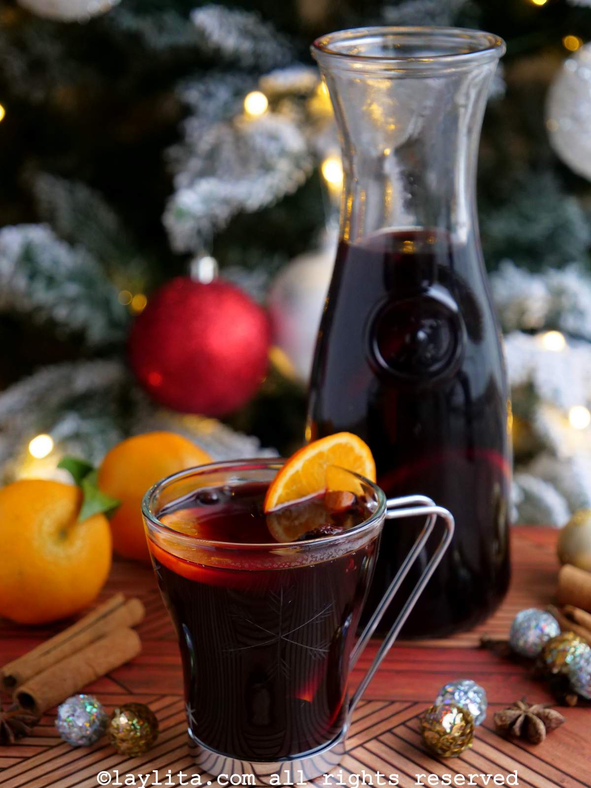 Vino Caliente en un vaso con una jarra de vino en el fondo