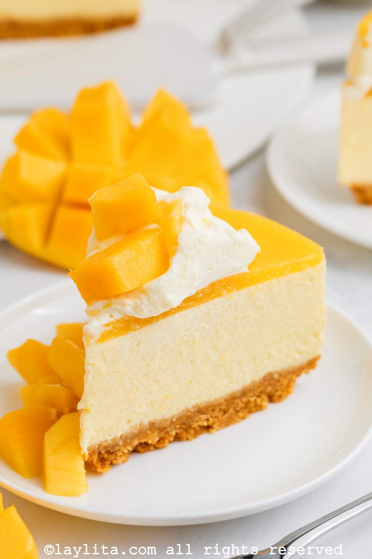 Una rebanada de cheesecake de mango sin hornear en un plato blanco 