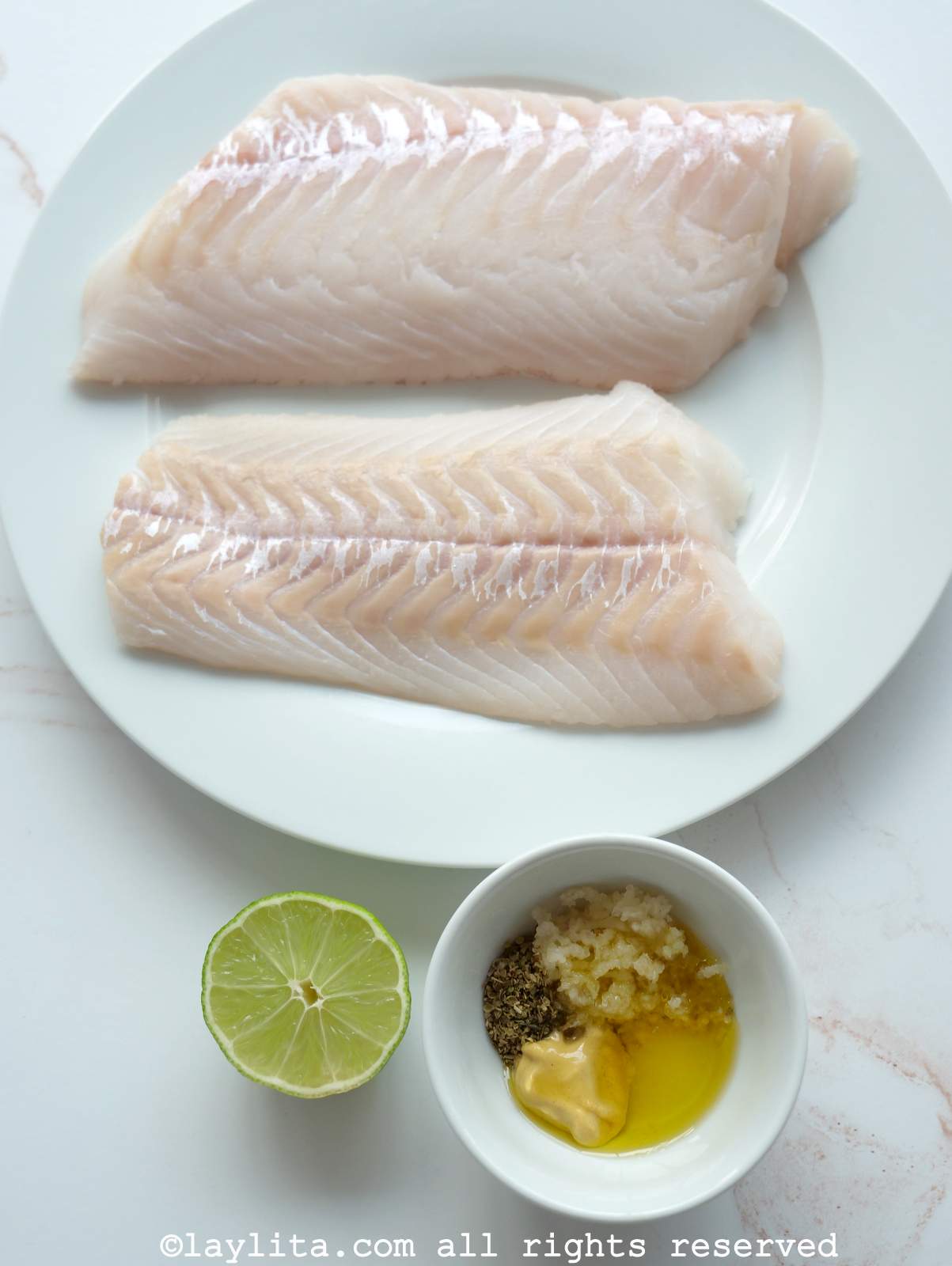 Ingredientes para hacer Pescado a la Plancha en una superficie de cocina