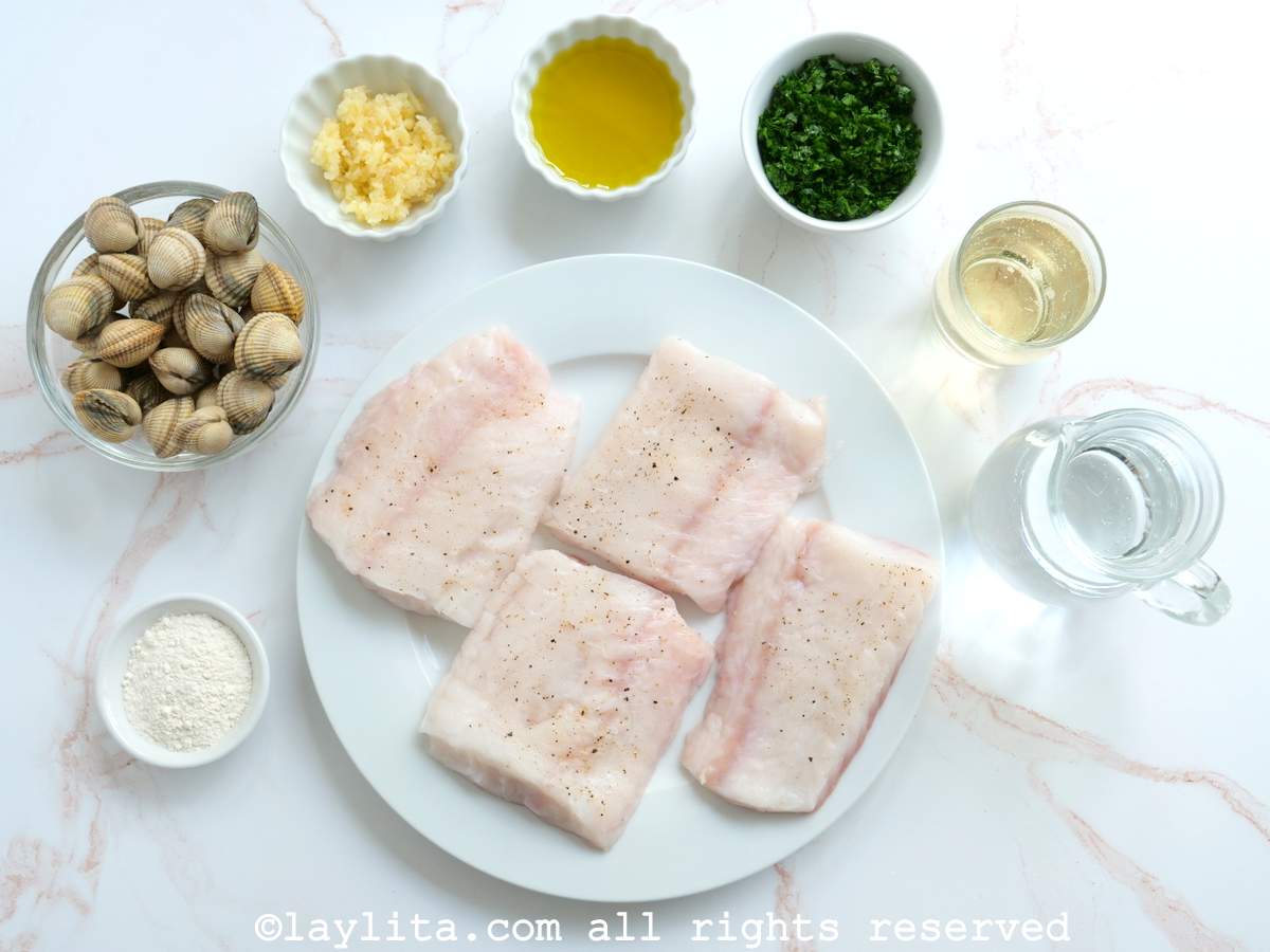 Ingredientes para preparar pescado o merluza en salsa verde en una mesa de cocina