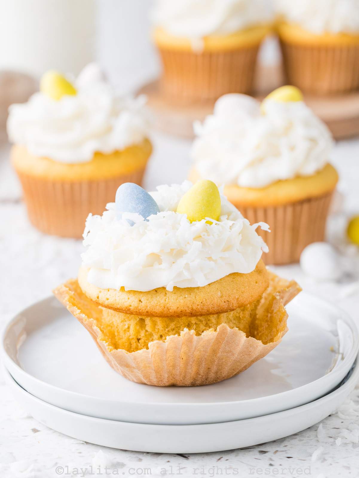 Un cupcake sin el capacillo, con varios cupcakes al fondo.