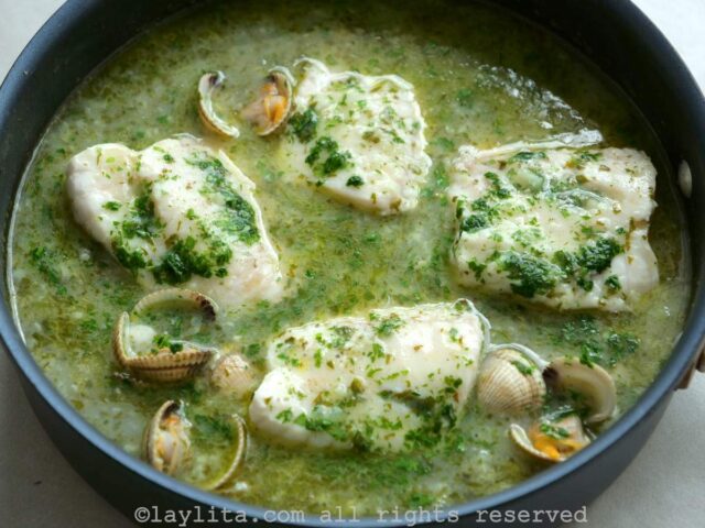 Pescado y almejas cocinandose en salsa verde de ajo y perejil