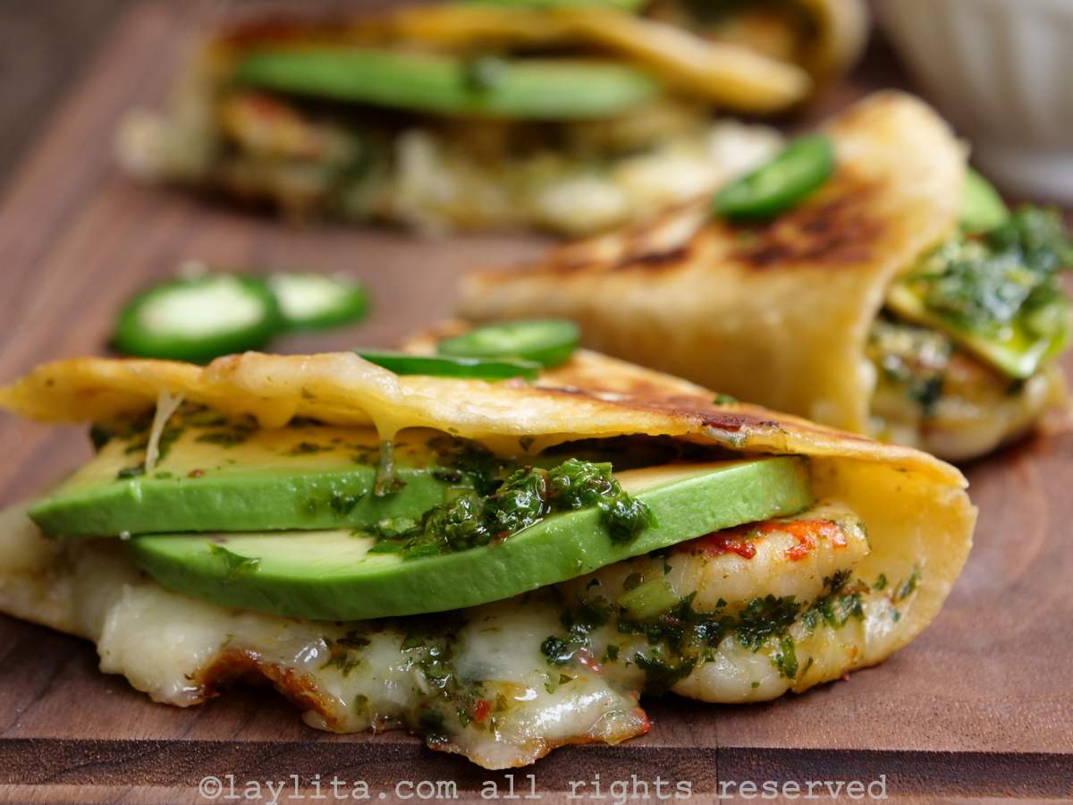 Quesadilla de camarones con aguacate y chimichurri encima de una tabla de madera